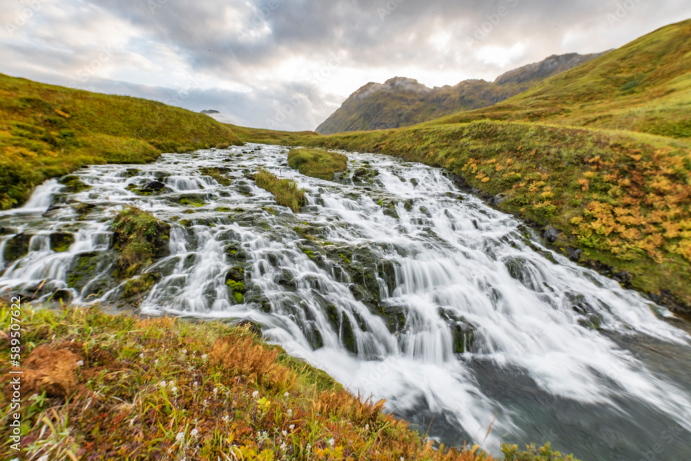 View of a waterfall with river on Unalaska Island, Unalaska, Alaska, United States. View of a waterfall with river on Unalaska Island, Unalaska, Alaska, United States.