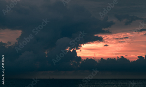 Dark cloudy tropical sunset sky over the ocean, natural background