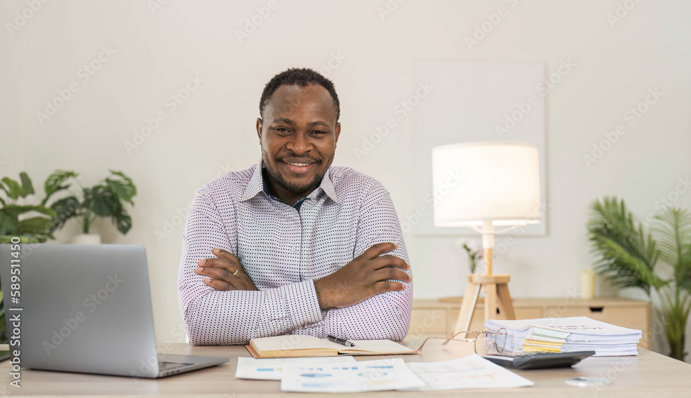 Portrait of handsome African black young business man working on laptop at office desk. Portrait of handsome African black young business man working on laptop at office desk.