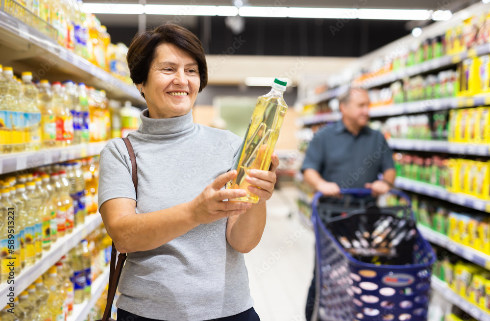 woman chooses oil in supermarket