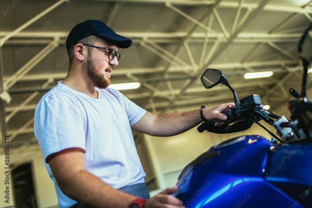 Naklejka premium Professional motorcycle mechanic working in bike repair service