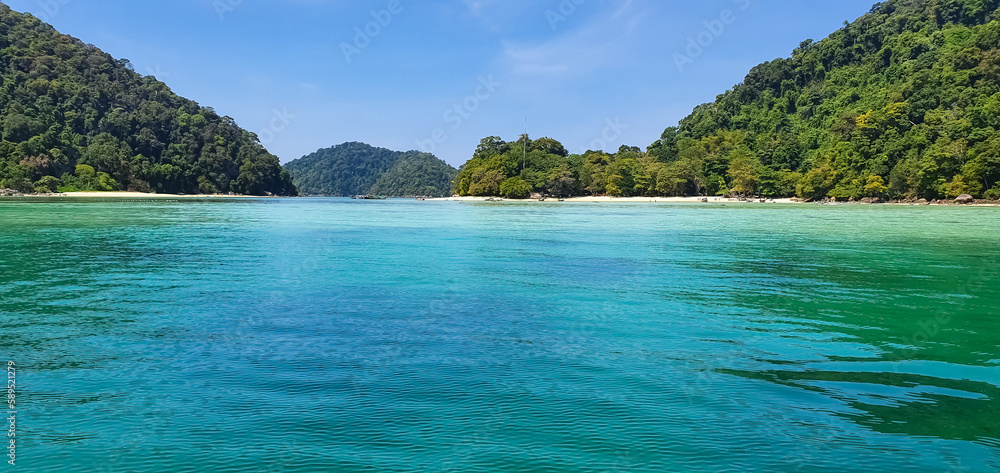 Scenic view of Island's peaceful white sand beach and crystal clear turquoise sea water bay with tropical tree at horizon. Summer vibe.amazing tropical nature background. Beautiful bright sea