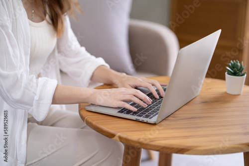Business woman working from home. work online on laptop. Asian businesswoman working on sofa online business with social distancing laptop online meeting.