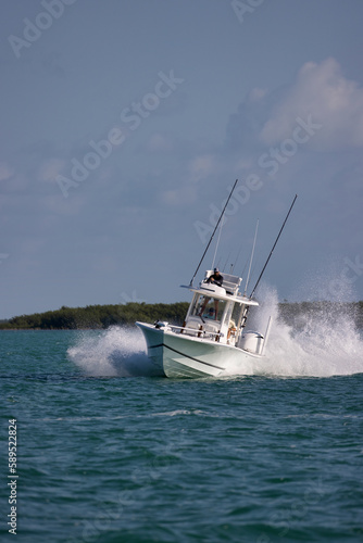 Speeding center console fishing boat throwing spray.