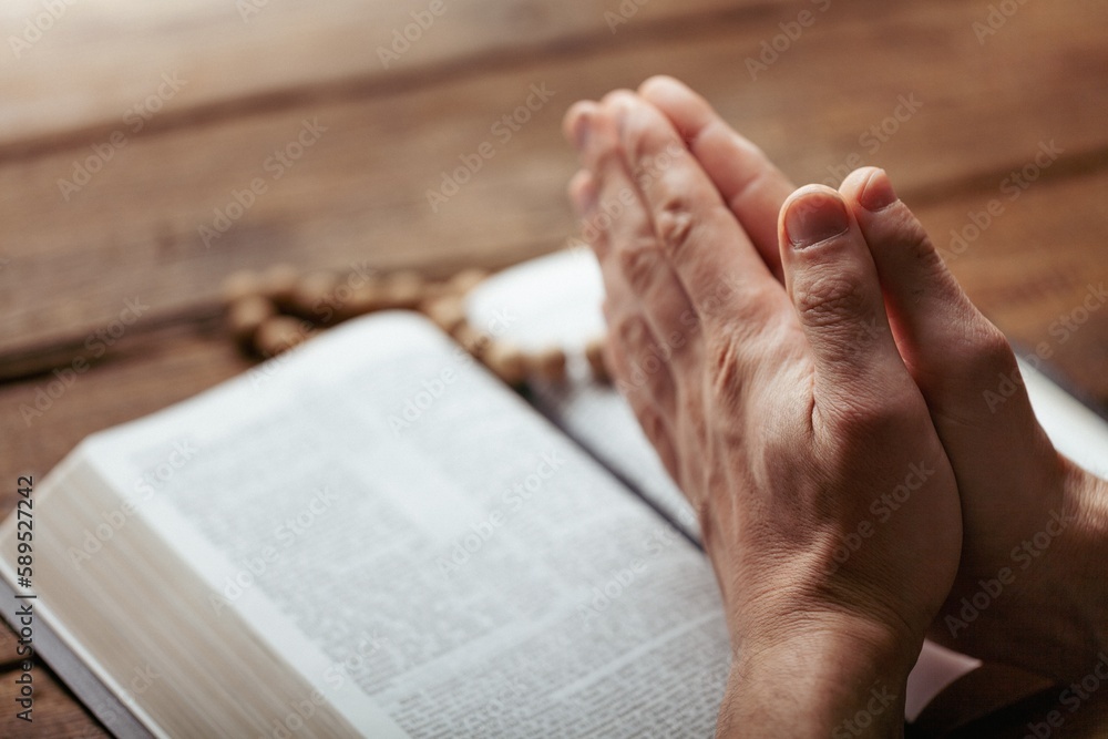 Naklejka premium Man hands praying on the bible. Concept religion