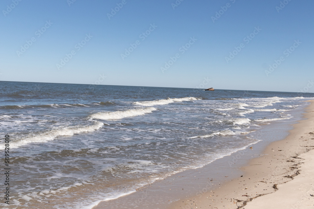I love this look of the waves battering the beach. The white caps of the surf as it pummels the sand. The beautiful cloudless sky in the background makes the pretty sea stand out. This is Cape May.