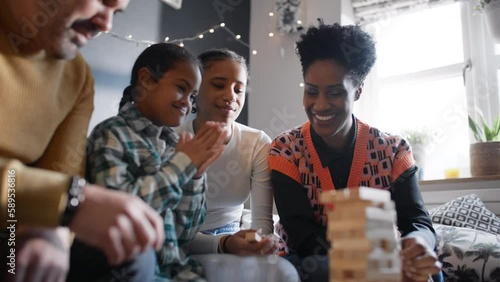 Boy with Down syndrome playing game with family watching