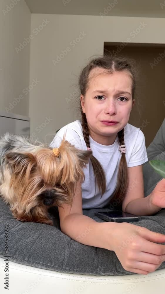 a little girl plays in a mobile phone, eats fruits and treats her dog with food, the concept of care and love for pets, a girl feeds a dog with fruits a little girl plays in a mobile phone, eats fruits and treats her dog with food, the concept of care and love for pets, a girl feeds a dog with fruits