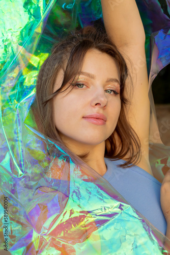 Young woman posing with holographic foil. Dreamy self expression concept beauty portrait 