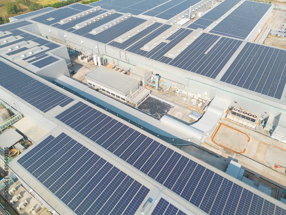 Fototapeta premium Aerial view of solar panels or solar cells on the roof of factory building rooftop. Power plant, renewable clean energy source. Eco technology for electric power in industry.