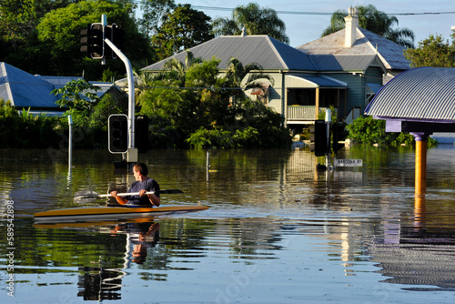 Flooded residential street with man in a canoe