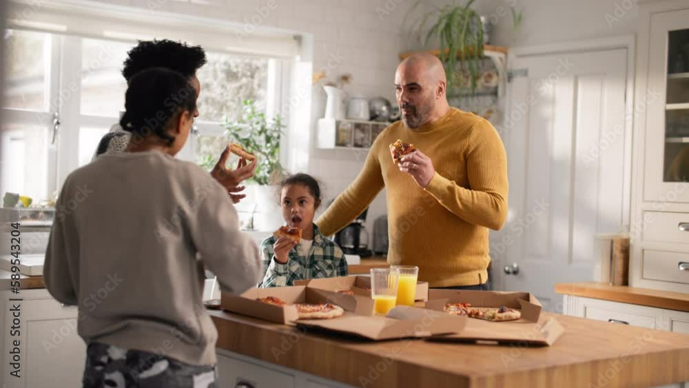 Family enjoying takeaway pizza in kitchen Family enjoying takeaway pizza in kitchen