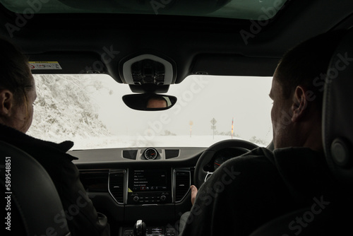 couple driving car on icy roads in the mountains photo