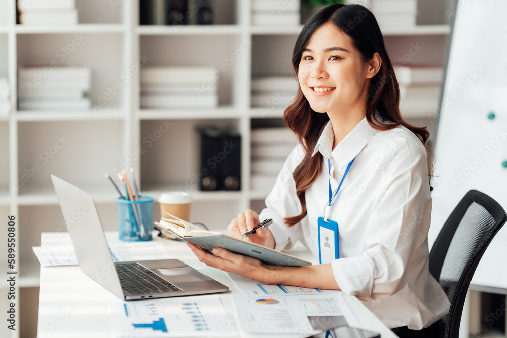 Young Asian Businesswomen smiling and happy used laptop working in the office. Young Asian Businesswomen smiling and happy used laptop working in the office.