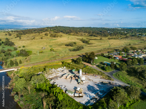 concrete factory plant with cement mixers beside railway and river photo