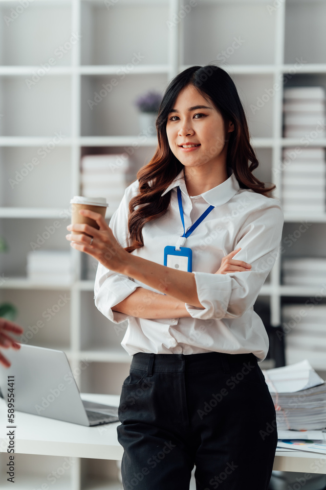 Young business woman holding coffee cup at the office. Young business woman holding coffee cup at the office.