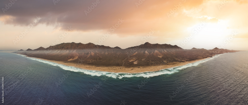 View from above, stunning panoramic view of Cofete beach surrounded by the chain of mountains of the Jandía Natural Park during a beautiful sunset. Fuerteventura, Canary Islands.