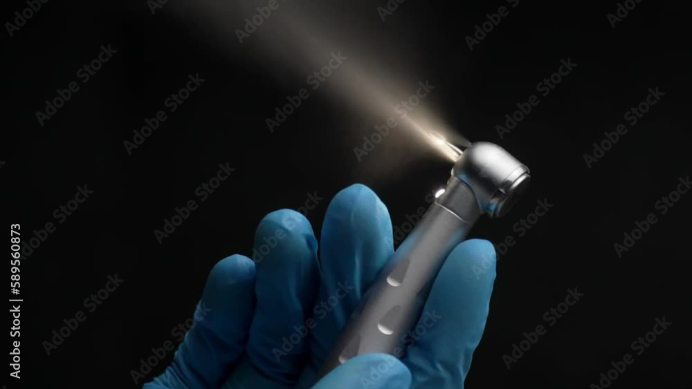 Dentist hand with drill illustrates operation of dentist dental drill