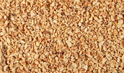 Fotografie Pile chopped and roasted hazelnut background and texture