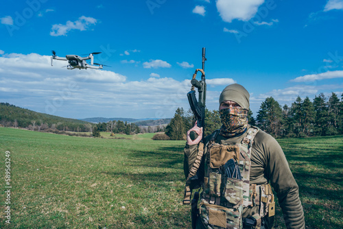 Modern army soldiers using aerial drone for artillery guidance and scouting view enemy positions in military operation.