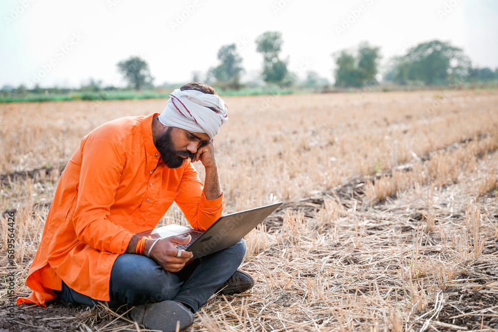 Young indian farmer in depression after see some detail in laptop. Young indian farmer in depression after see some detail in laptop.