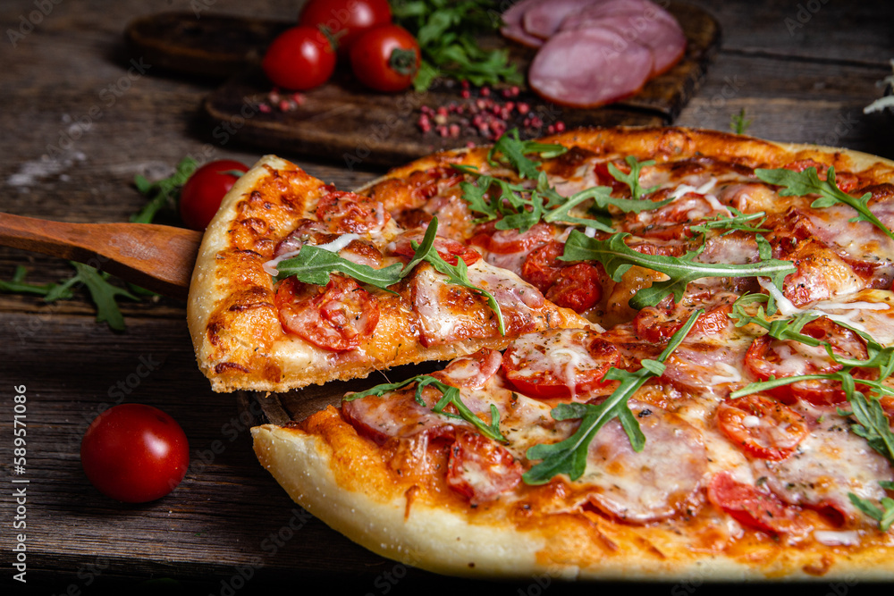 Appetizing pizza with ham on a wooden background Appetizing pizza with ham on a wooden background