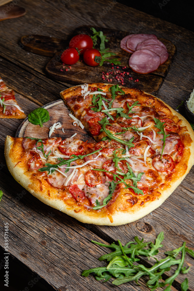 Appetizing pizza with ham on a wooden background Appetizing pizza with ham on a wooden background