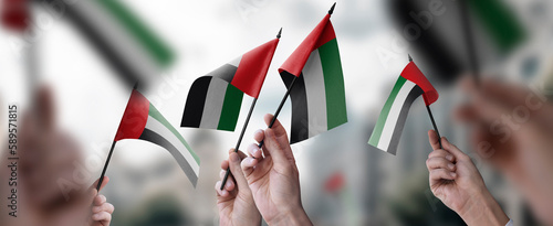 Valokuva A group of people holding small flags of the Arab Emirates in their hands