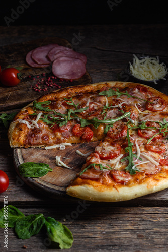 Appetizing pizza with ham on a wooden background