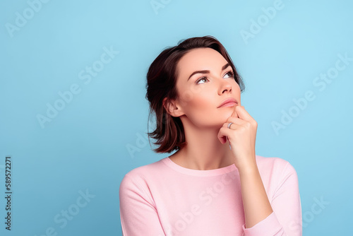 Portrait d'une jeune femme brune en pull rose en train de réfléchir, de penser la main sous le menton le regard vers le ciel, fond bleu clair - IA générative