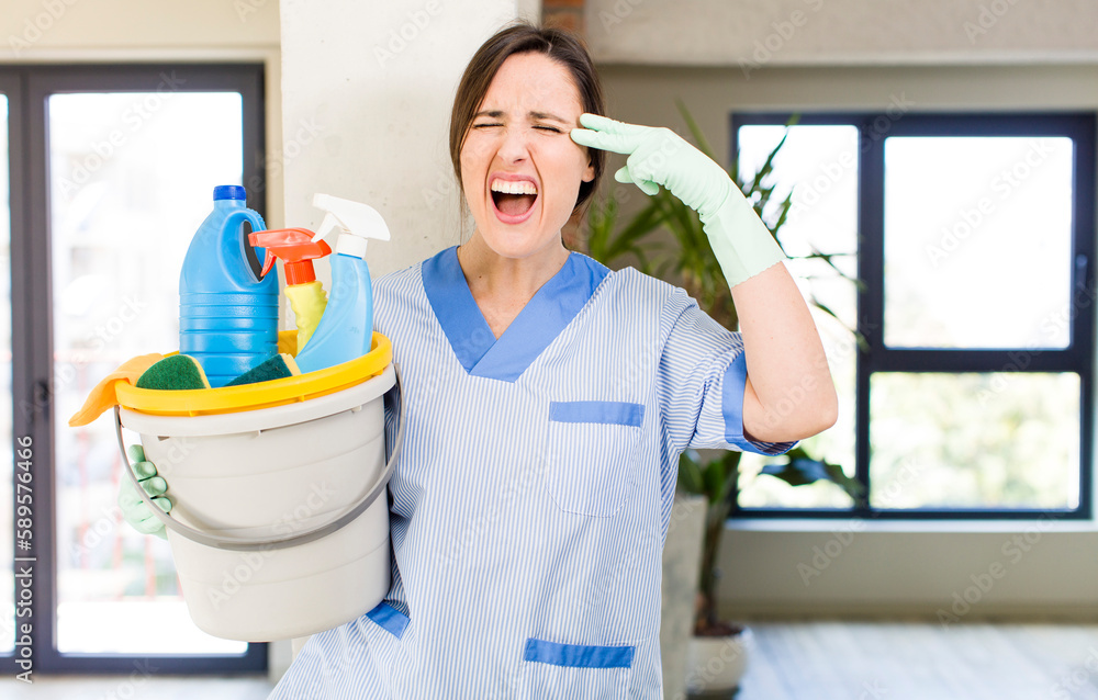 young pretty woman looking unhappy and stressed, suicide gesture making gun sign. housekeeper concept young pretty woman looking unhappy and stressed, suicide gesture making gun sign. housekeeper concept