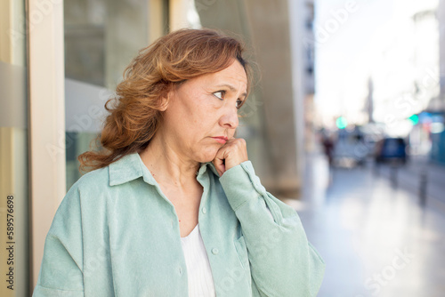 middle age woman feeling sad and stressed, upset because of a bad surprise, with a negative, anxious look