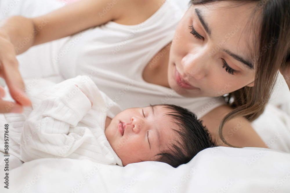 happy loving family. mother playing with her baby hugging in the bedroom , portrait of asian mother playing with newborn baby, health care family love together. asian girl lifestyle.. happy loving family. mother playing with her baby hugging in the bedroom , portrait of asian mother playing with newborn baby, health care family love together. asian girl lifestyle..
