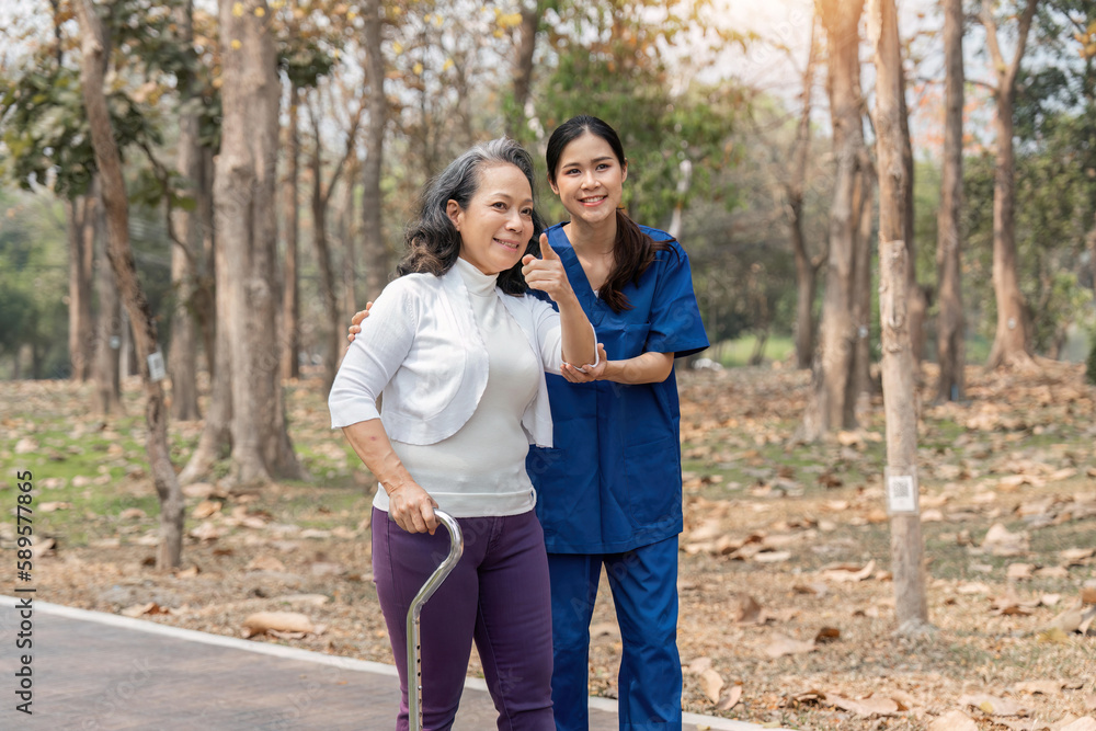 nurse helping elderly woman with walker Nurse holding hand and help elderly woman walking in park facility nurse helping elderly woman with walker Nurse holding hand and help elderly woman walking in park facility