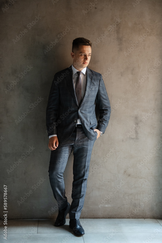 portrait of a groom in a gray plaid suit with a tie portrait of a groom in a gray plaid suit with a tie