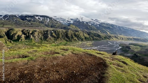 Hiker man hiking to Valahnukur trail viewpoint with moody sky in summer among Icelandic Highlands at Thorsmork photo