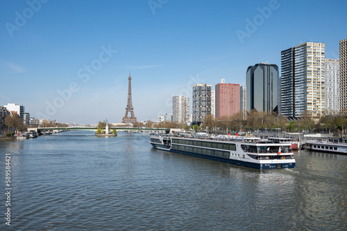 Paris, France - 04 05 2023: View of the Statue of Liberty, Grenelle bridge, Eiffel tower, vessal cruise ship and neighborhood building from Mirabeau Bridge. © Franck Legros