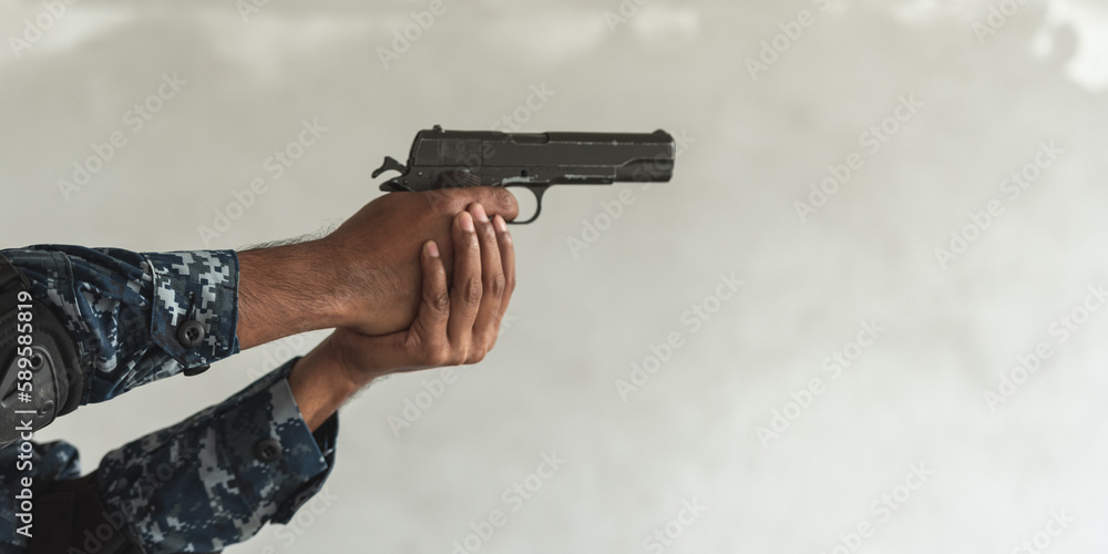 Φωτογραφία Hand of Police cop constable holding Pistol Is preparing to shoot bandit culprit in abandon building