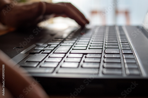 Persona escribiendo con el teclado de su laptop. Fotografía con desenfoque selectivo