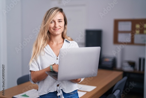 Young blonde woman business worker smiling confident using laptop at office