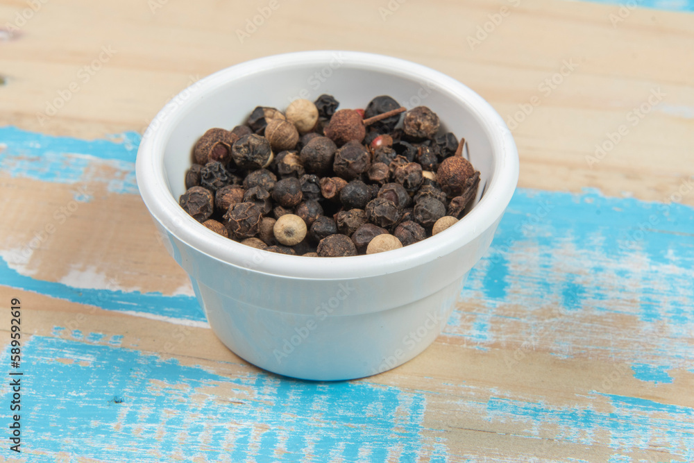 bowl with ground black pepper on blue rustic wooden table bowl with ground black pepper on blue rustic wooden table
