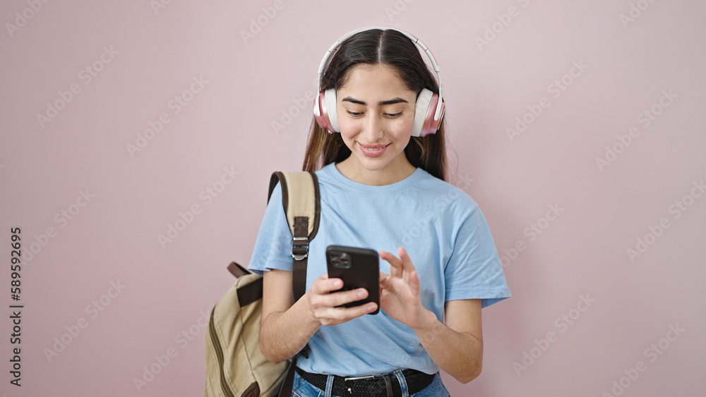 Young beautiful hispanic woman student using smartphone and headphones at street Young beautiful hispanic woman student using smartphone and headphones at street