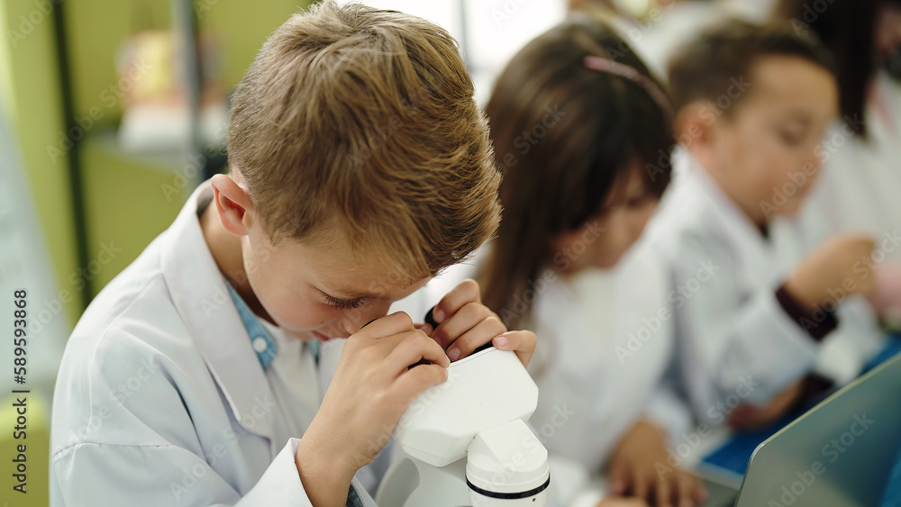 Obraz premium Group of kids students using microscope at laboratory classroom