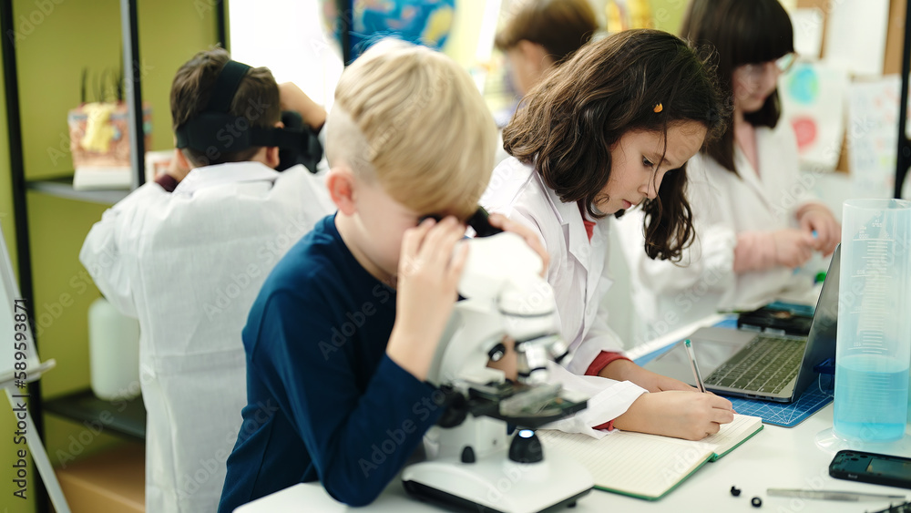 Group of kids students using microscope at laboratory classroom Group of kids students using microscope at laboratory classroom