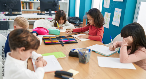 Group of kids students sitting on table studying at classroom