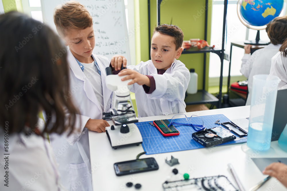 Fototapeta premium Group of kids students using microscope repairing smartphone at laboratory classroom