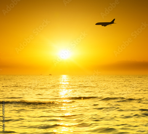 plane fly over water during sunrise © Andrii Salivon