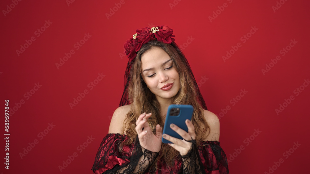 Young beautiful hispanic woman wearing katrina costume using smartphone over isolated red background Young beautiful hispanic woman wearing katrina costume using smartphone over isolated red background