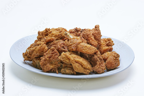Pile of Crispy Fried Chicken with flour coating  on a plate, isolated white background
