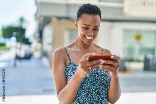 African american woman smiling confident watching video on smartphone at street © Krakenimages.com